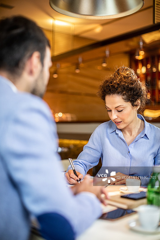 女CEO在餐厅开会时写下了一些事情图片素材