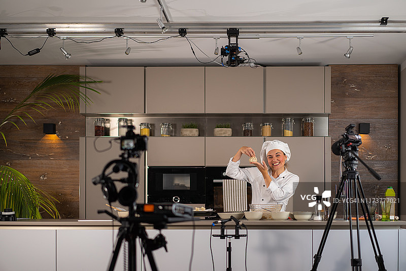 视频博客，快乐的女厨师youtube博主影响者在厨房为新视频工作图片素材