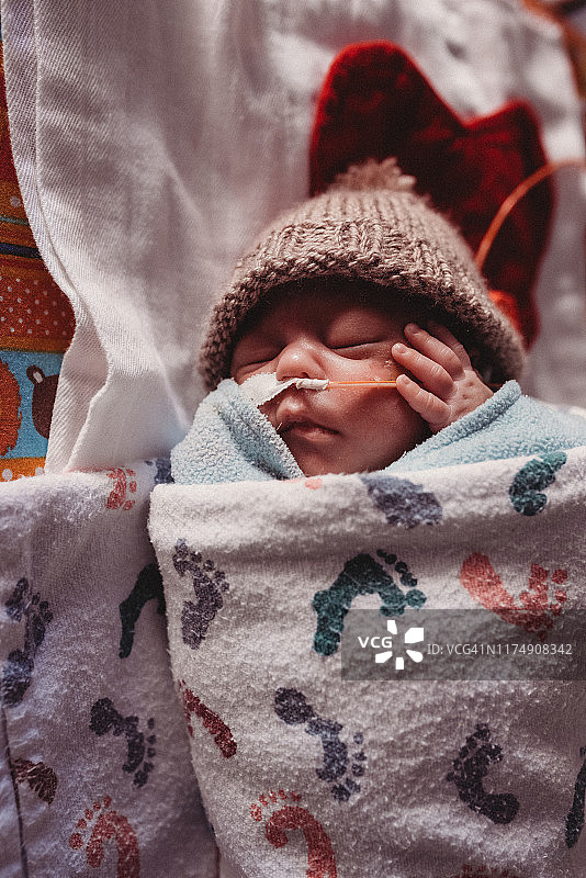 29周早产儿在新生儿重症监护室的开放式金属婴儿床里睡觉图片素材