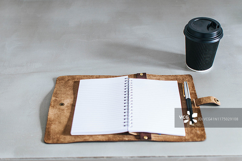 一个个人记事本和桌上的一次性咖啡杯图片素材