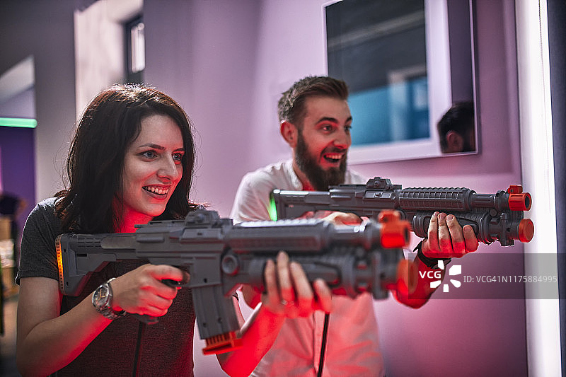 快乐的夫妇玩和射击步枪在游乐场图片素材