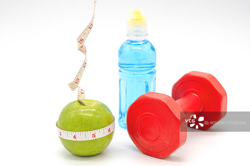 健身器材。健康食品。白色背景上的苹果，哑铃和卷尺。从上面的观点图片素材