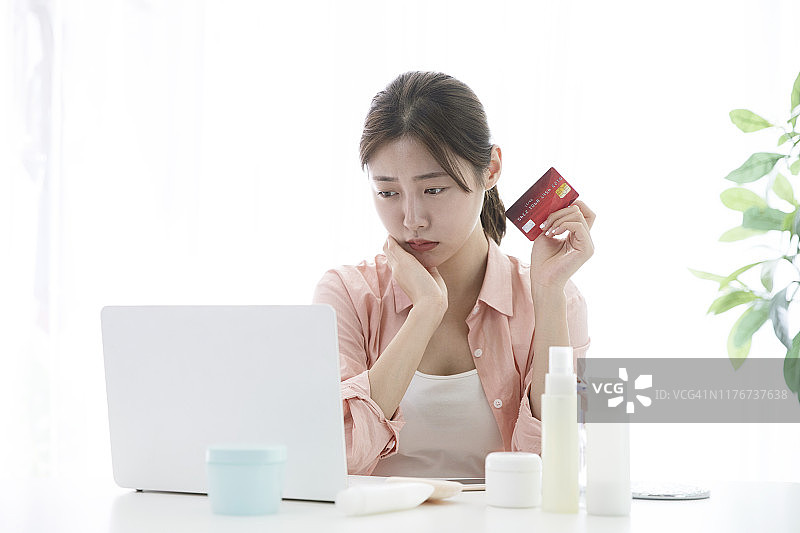 忧心忡忡的女人用信用卡在网上购物图片素材