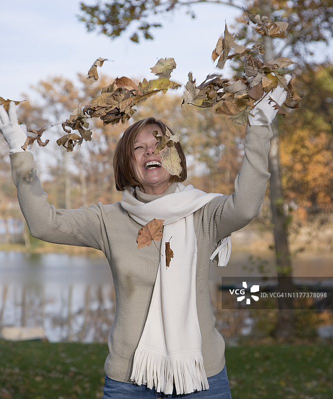 快乐的女人扔着秋叶图片素材