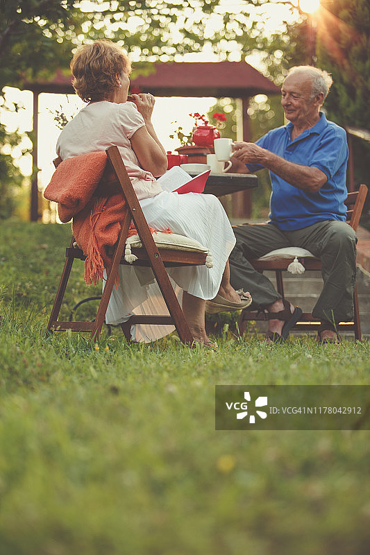 一对老年夫妇在花园里享用茶点图片素材