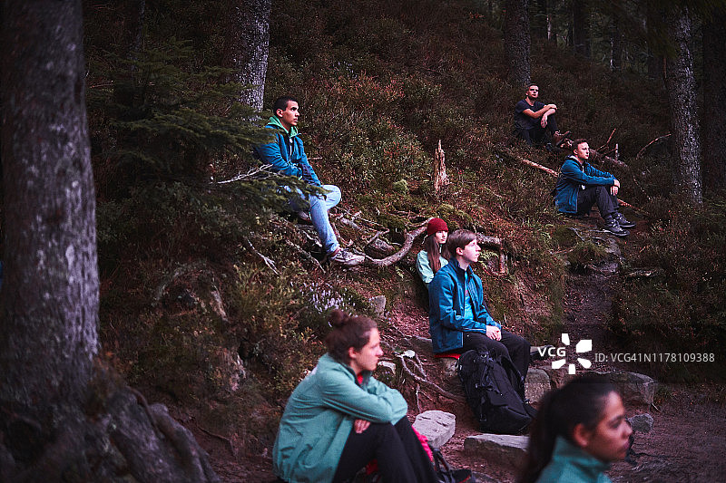 一群年轻人坐在户外的山坡上图片素材