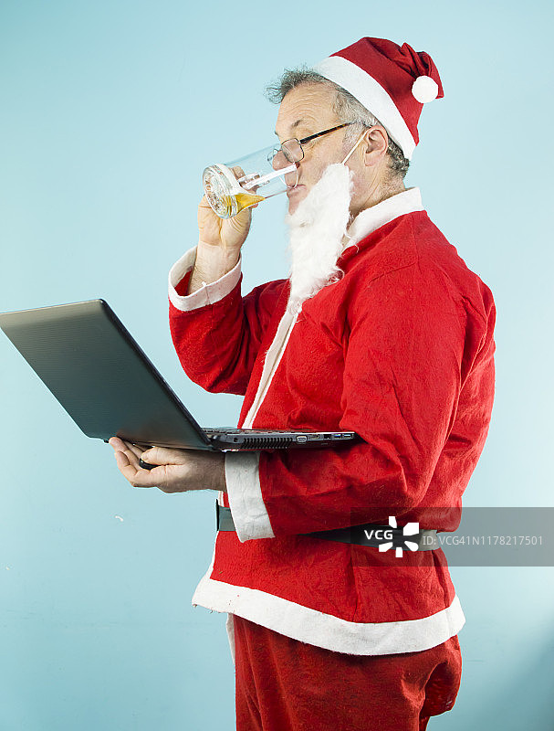 打扮成圣诞老人的商人在用电脑工作图片素材