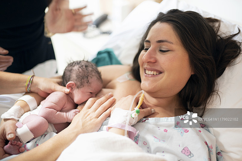 母亲在病房母乳喂养新生儿，第一次母乳喂养图片素材