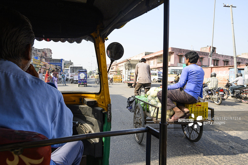 一名身份不明的司机骑着机动三轮车穿过斋浦尔繁忙的街道。图片素材