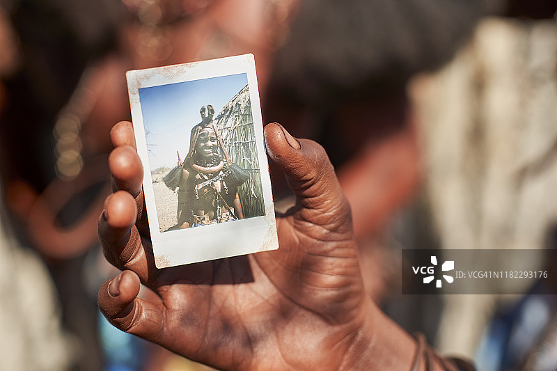 安哥拉奥诺卡，穆丁巴部落妇女展示自己的照片。图片素材