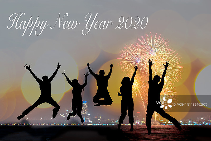 剪影快乐的企业团队跳跃欢呼人群烟花庆祝毕业在2020年新年快乐。自由生活方式组的人跳作为数字2020的一部分图片素材