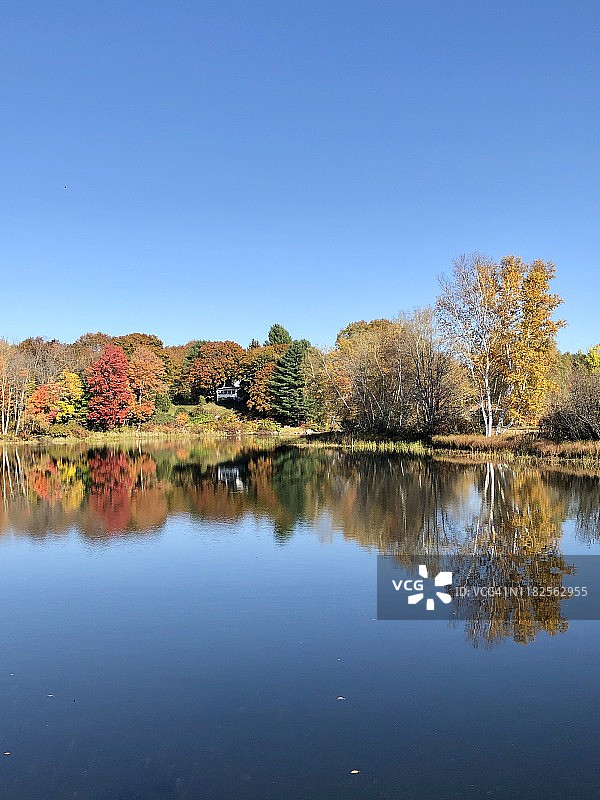 美国缅因州奥本湖附近的小房子和秋天的树反射图片素材