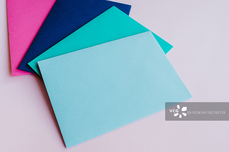 浅色背景上的彩色纸信封。新邮件，写消息。收发信件。邮政递送服务。空白的信封，空白的空间。人沟通,文书工作。信封特写镜头图片素材