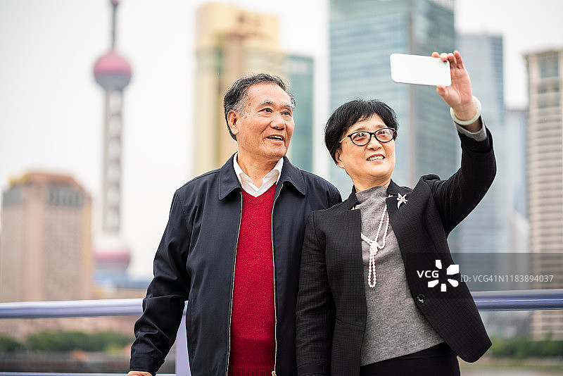一对亚洲老夫妇在上海旅游时自拍图片素材