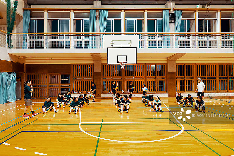 两个教练给建议和指导的年轻女孩在一个团队排球练习图片素材