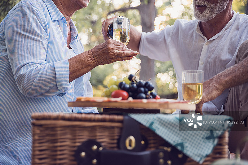 一个男人在野餐时对着一个女人喝白葡萄酒图片素材