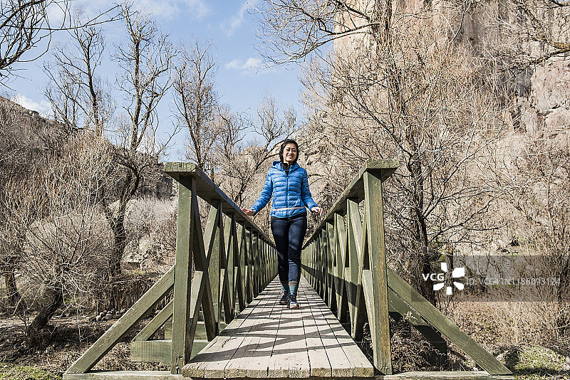 Woman crossing wooden bridge in forest, Göreme, Cappadocia, Nevsehir, Turkey图片素材