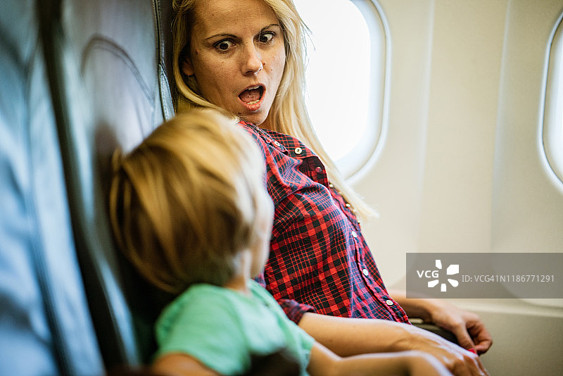 年轻妇女和小男孩第一次坐飞机图片素材