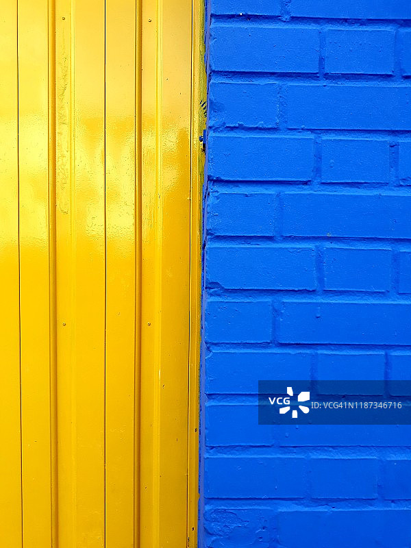 蓝色砖墙和黄色金属门图片素材