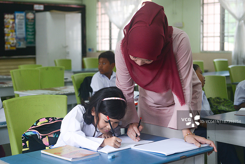 亚洲女教师戴着头巾在教室里教小学生图片素材