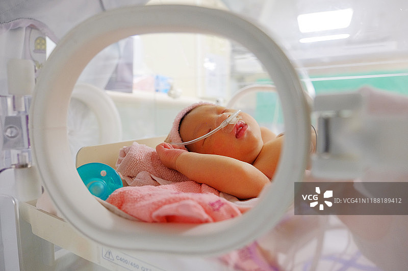 刚出生的婴儿在保温箱和奶嘴图片素材