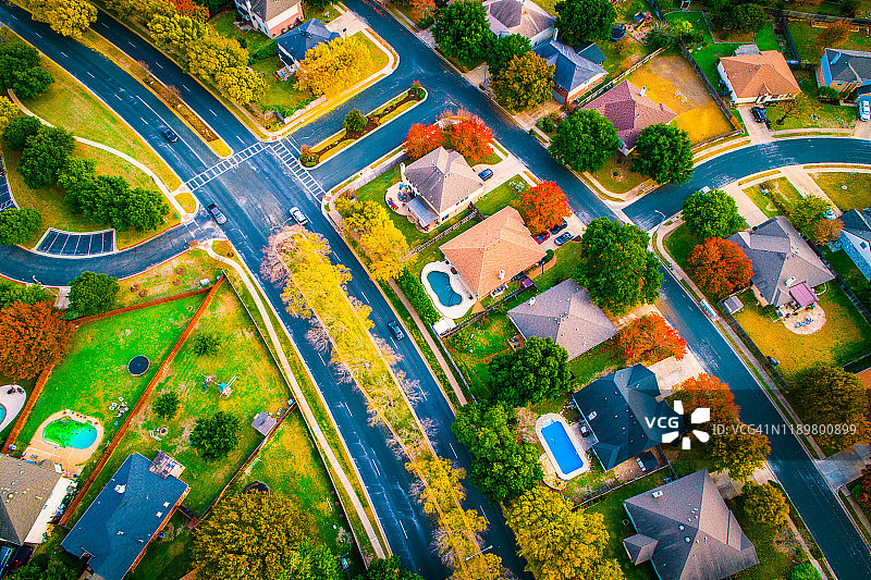 弯曲的道路，无人机俯瞰郊区现代住宅开发的秋色图片素材