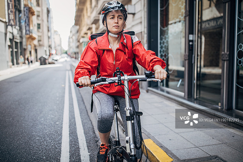 骑自行车送披萨的女人在城里图片素材