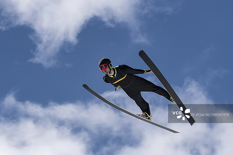 前视图的男子跳台滑雪在半空中对多云的天空图片素材