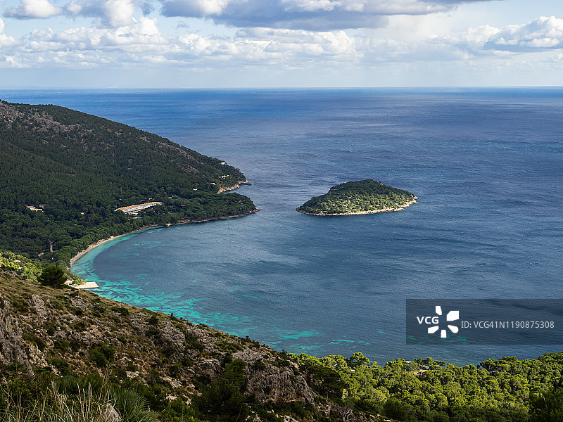 在马略卡岛海岸有一个小岛，山脉，悬崖和蓝绿色的海水图片素材