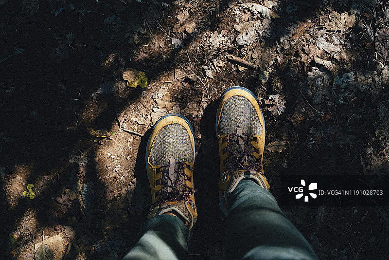秋天的远足靴踩在满是树叶的小路上图片素材