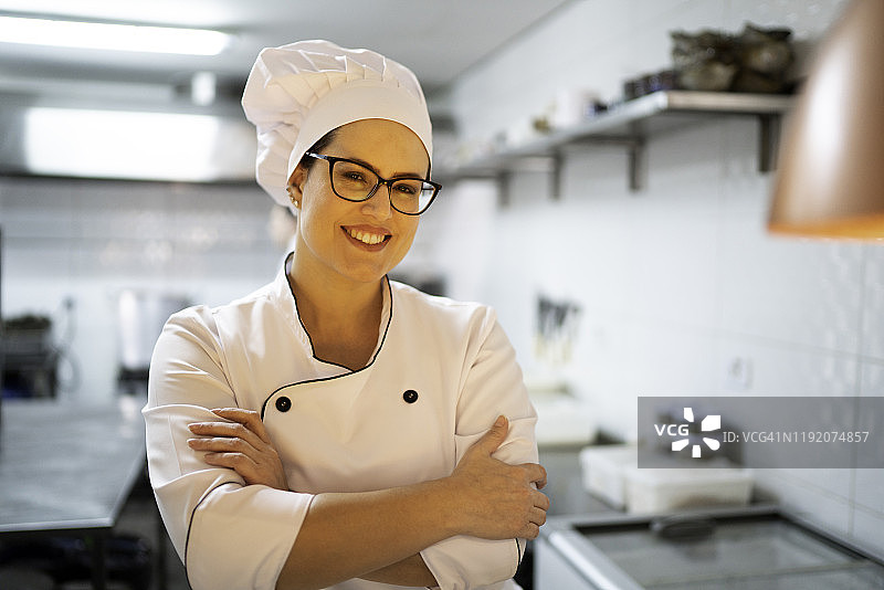 一个微笑的女厨师在餐厅的肖像图片素材