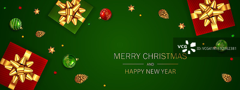 礼盒与金色的假日弓和圣诞球在绿色的背景图片素材