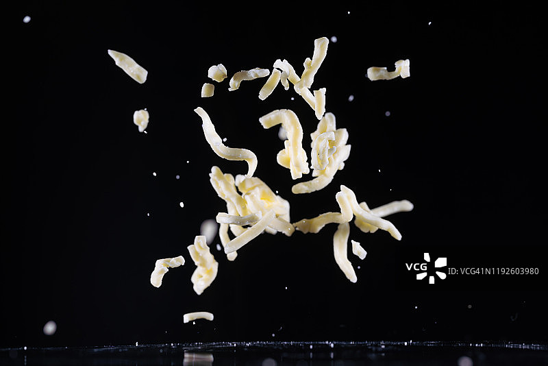 高速同步捕捉飞在半空中的马苏里拉奶酪丝。“n图片素材