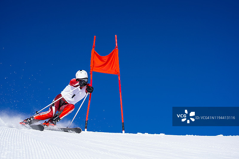 专业高山滑雪者在湛蓝的天空下滑雪图片素材