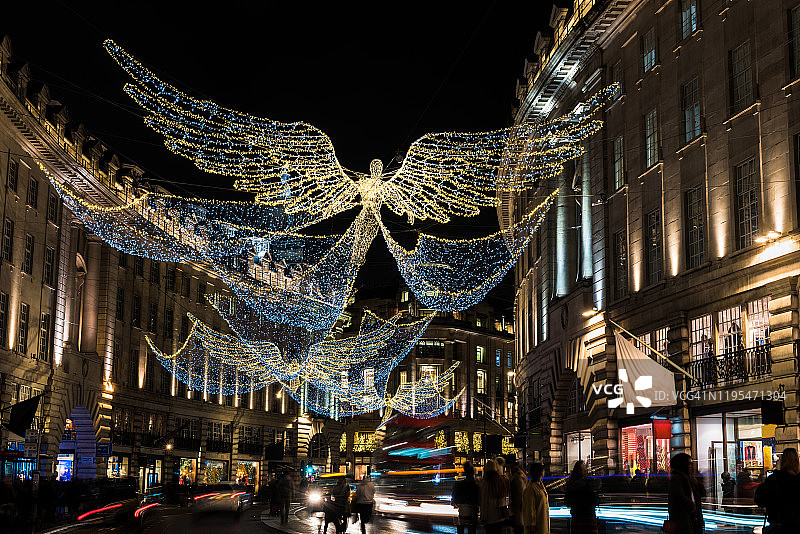 圣诞灯，购物者和交通在晚上，摄政街，伦敦，英国。图片素材