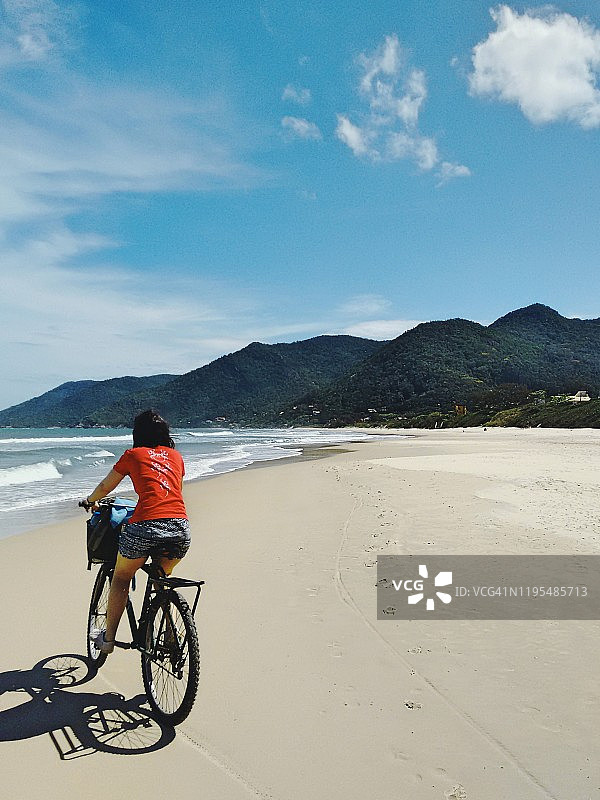 在海滩上骑自行车的女孩图片素材