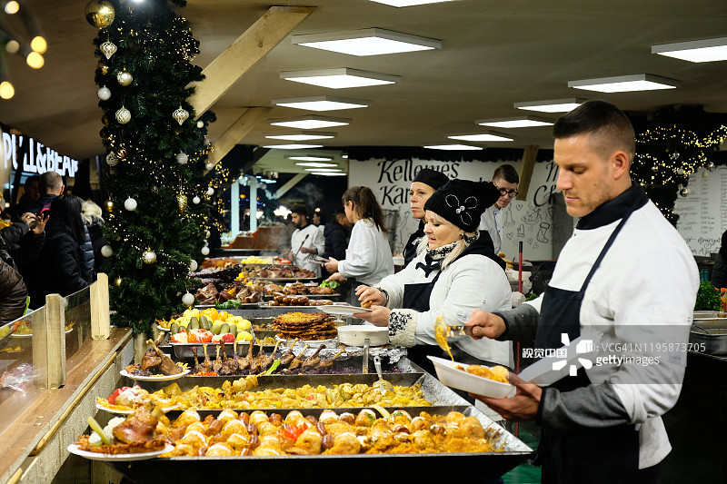 布达佩斯,匈牙利。12月13日，小贩在布达佩斯假日街头市场烹制传统小吃。圣诞街头美食节在市中心集市，冬季假期。图片素材