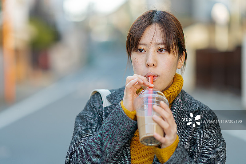 年轻女子喝木薯奶茶的肖像图片素材
