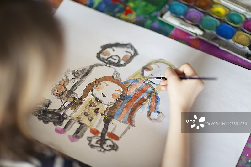 孩子在纸上画一个家庭和宠物站在一起的肖像图片素材