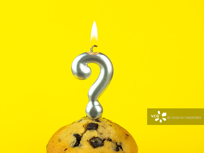黄底巧克力蛋糕上的问号生日蜡烛图片素材