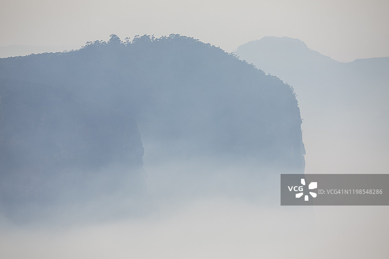 森林火灾烟雾在山谷和蓝色的山脉上升在烟雾，森林火灾，空气污染在澳大利亚图片素材