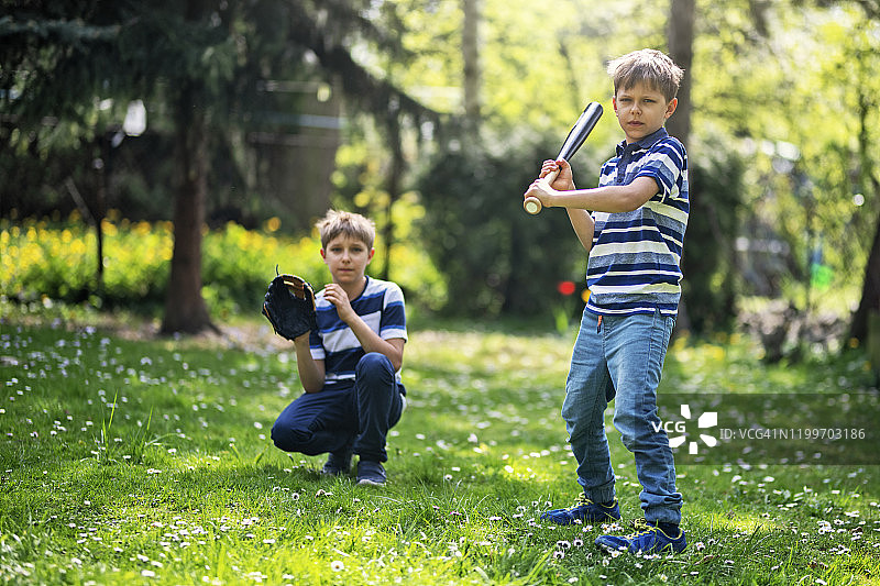 小男孩在后院打棒球图片素材