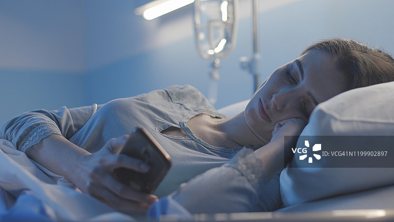 失眠患者躺在床上用手机聊天图片素材