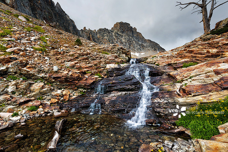 瀑布从岩石与汤普森峰的背景，锯齿山在爱达荷中部，夏日图片素材