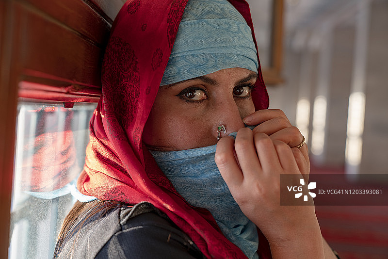 披着披肩的肖像。东方女人的肖像，年轻的阿拉伯女人戴着头巾和性感的黑眼睛图片素材
