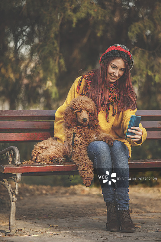 一个爱狗人士和她的宠物在公园里的照片图片素材