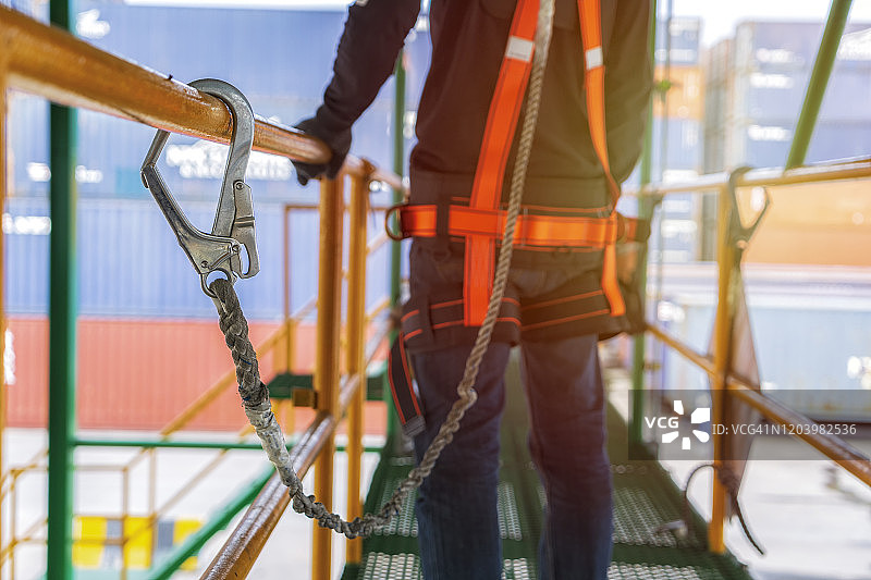 建筑工人在高层工地施工时使用安全带和安全带。图片素材