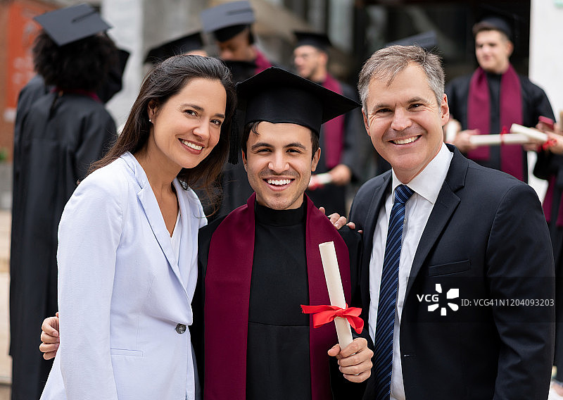 快乐的毕业生和他的父母微笑图片素材