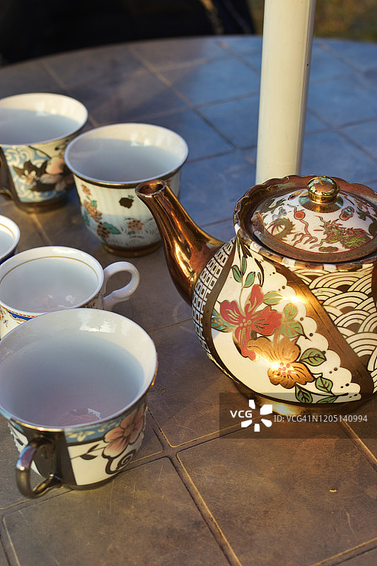 经典风格的玫瑰花饰瓷茶壶、茶杯、碟，孤立于白色之上图片素材