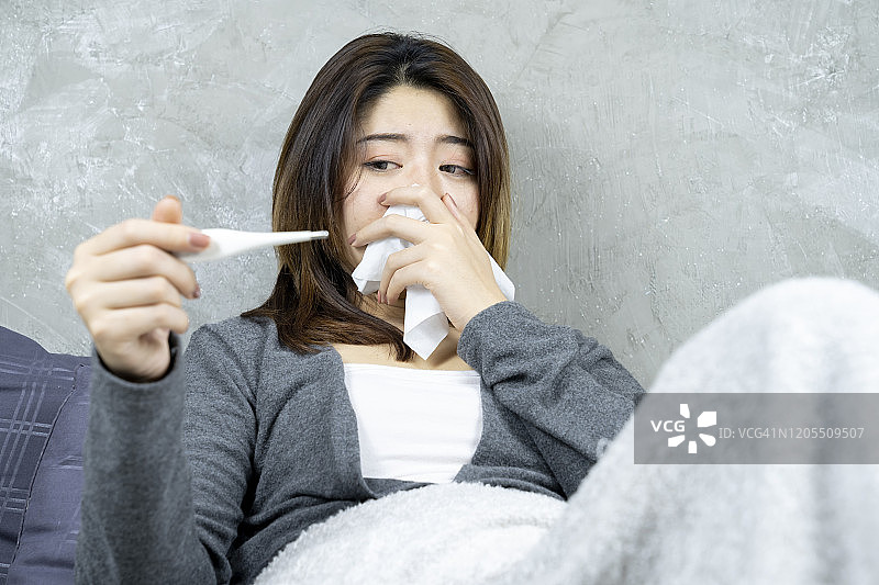 亚洲美女感冒病倒在床上图片素材